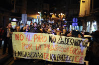 People protest with a banner, ''Not to unemployment. Not to evictions. For social protection'', during a march in Barakaldo, northern Spain.