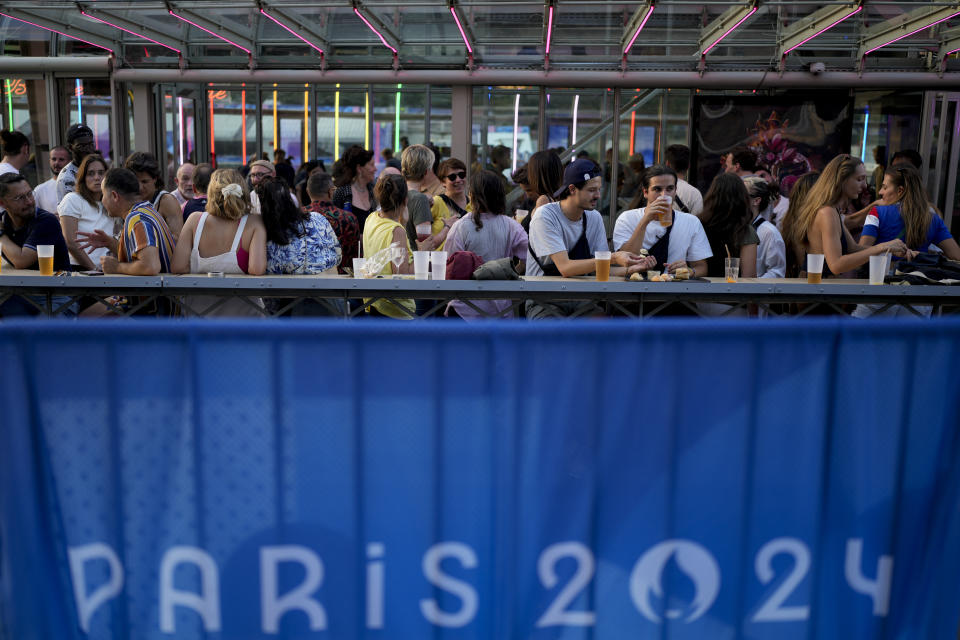 Asistentes a la inauguración de la Casa del Orgullo, el espacio seguro para la comunidad de atletas LGBT+, celebrada en el barco Rosa Bonheur sur Seine durante los Juegos Olímpicos de Verano de 2024, el lunes 29 de julio de 2024, en París, Francia. (Foto AP/Natacha Pisarenko)