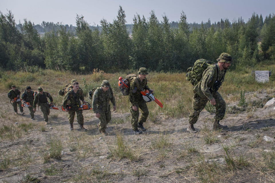 Canadian Armed Forces soldiers head to the forest to construct a firebreak behind Parker Recreation Field in Yellowknife to help fight wildfires on Wednesday, Aug.16, 2023. (Master Cpl. Alana Morin/Canadian Armed Forces via The Canadian Press