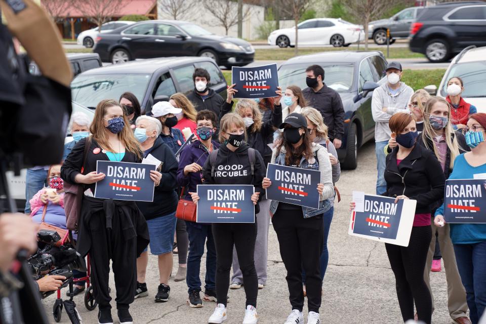 A small group of people held a vigil on Thursday night at Young's Asian Massage in Acworth, Ga., to call for an end to gun violence and hate directed toward the Asian community.