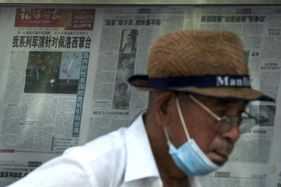 A man leaves after reading a newspaper with a photo of a plane carrying U.S. House Speaker Nancy Pelosi lands at Songshan Airport in Taipei, Taiwan with a headline reporting "Our series of military exercises are aimed at Pelosi channeling Taiwan" at a stand in Beijing, Wednesday, Aug. 3, 2022. After weeks of threatening rhetoric, China stopped short of any direct military confrontation with the U.S. over the visit of Pelosi to Taiwan. (AP Photo/Andy Wong)