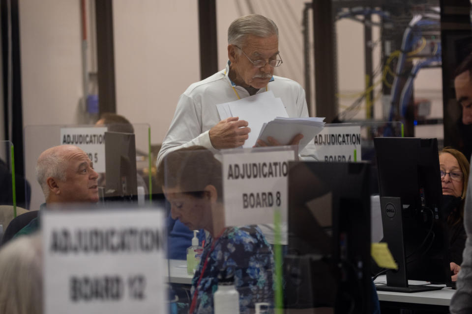 An adjudication board reviews ballots at the Maricopa County Tabulation and Election Center on Nov. 8 in Phoenix. 