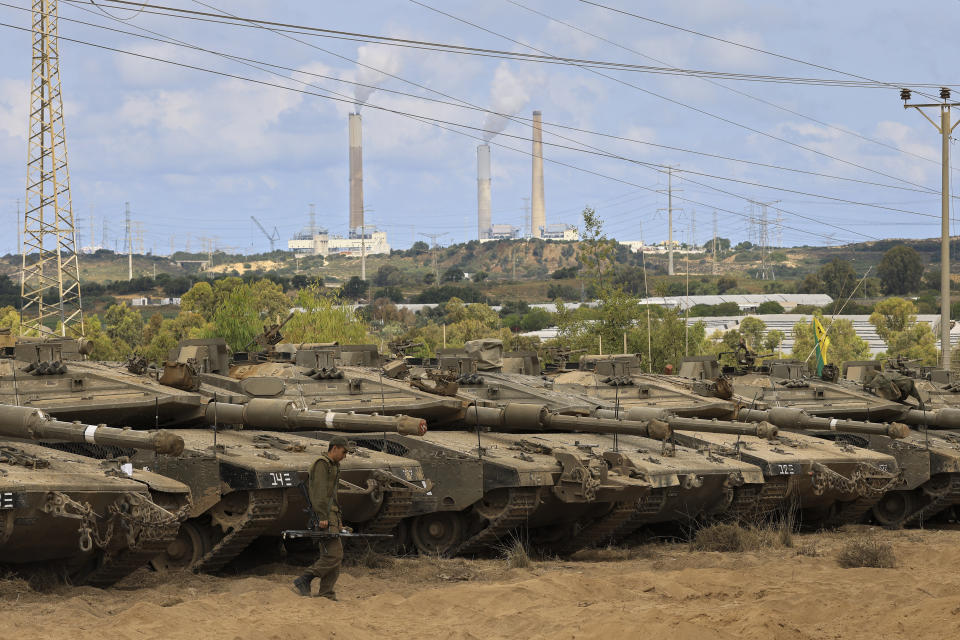 An Israeli soldier walks in a staging ground near the border with Gaza Strip, southern Israel, Friday, May 21, 2021. A cease-fire took effect early Friday after 11 days of heavy fighting between Israel and Gaza's militant Hamas rulers that was ignited by protests and clashes in Jerusalem. (AP Photo/Tsafrir Abayov)