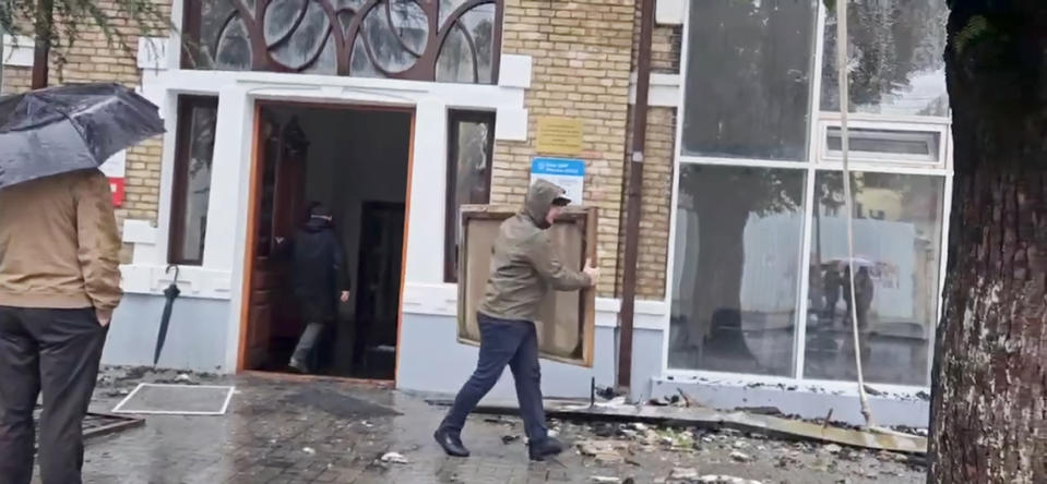 This photo taken from video shows Gallery employees taking out painting from the National Art Gallery in Abkhazia, in Sukhumi the capital of the separatist Georgian region, Sunday, Jan. 21, 2024. Thousands of artworks have been destroyed in a fire that swept through the main art gallery in Abkhazia in a severe blow to the cultural heritage of the separatist Georgian region. (AP Photo/Robert Dzhpua)