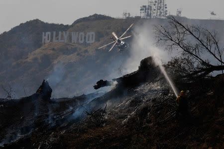 Firefighters work on a fire near the landmark Griffith Observatory in the hills overlooking Los Angeles, California, U.S. July 10, 2018. REUTERS/Patrick T. Fallon