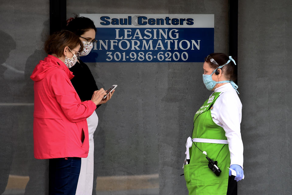 People wearing face masks walk past a leasing sign in front of a store amid the coronavirus pandemic on May 14, 2020 in Arlington, Virginia. - Another 3 million people filed initial unemployment claims last week on a seasonally adjusted basis, according to the Department of Labor. (Photo by Olivier DOULIERY / AFP) (Photo by OLIVIER DOULIERY/AFP via Getty Images)