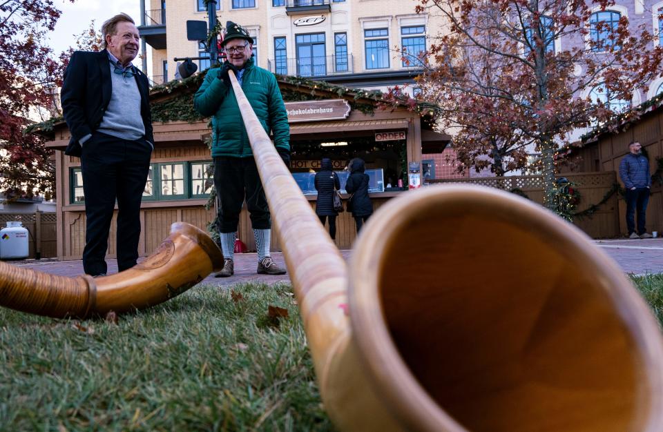 James Brainard, mayor of Carmel, talks with an Alphorn player during a soft opening of the Christkindlmarket on Thursday, Nov. 18, 2021 in Carmel. Due to COVID-19, the iconic Christmas market was canceled. Now the market is open for the holiday season. 