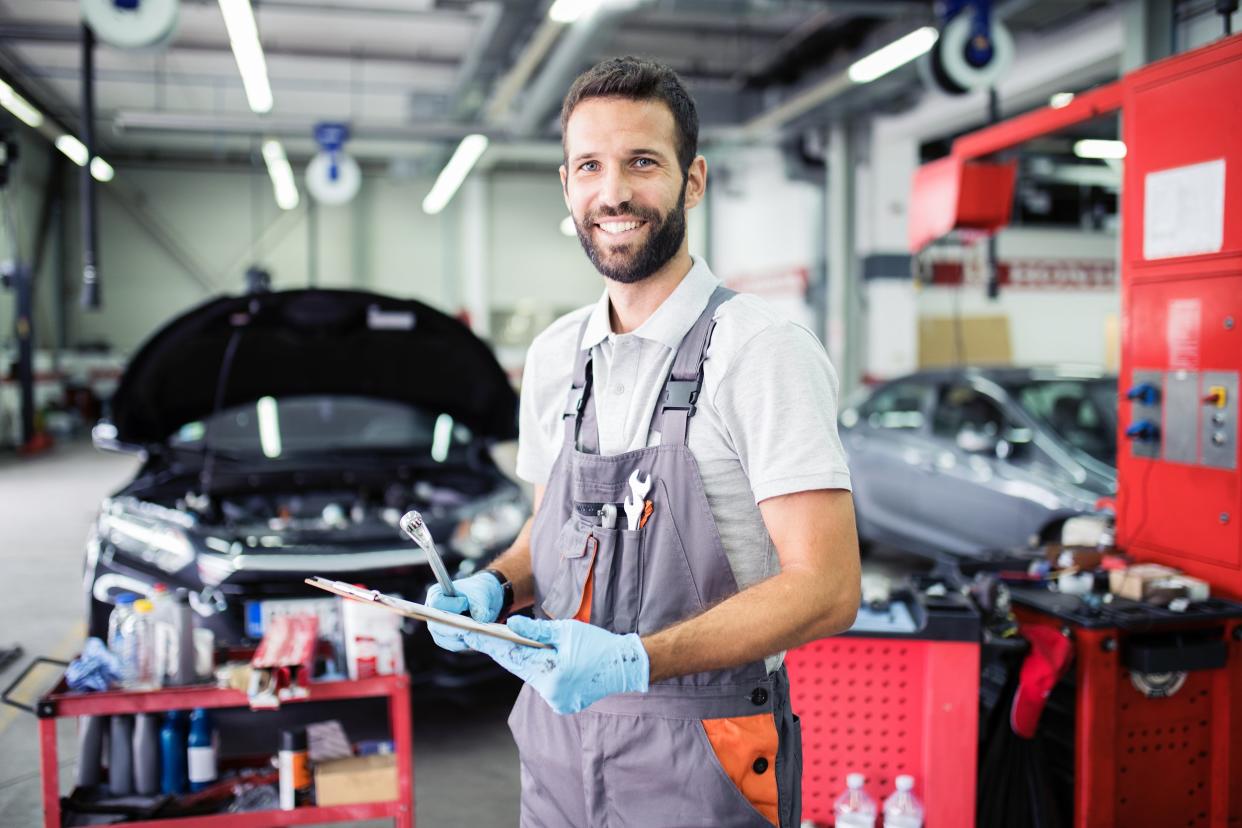 smiling car mechanic in shop