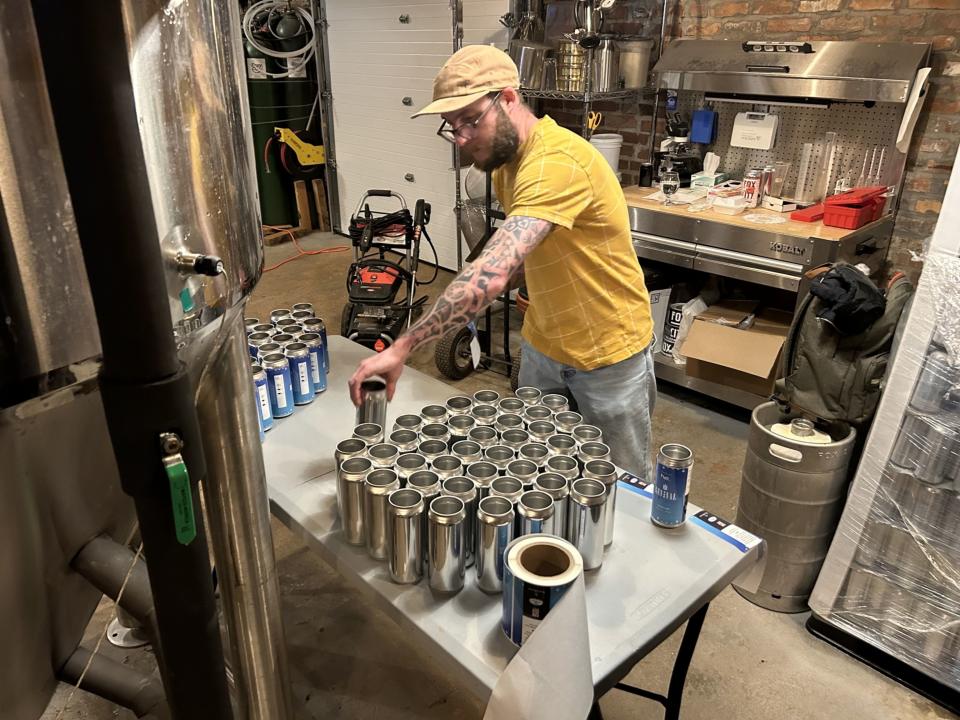 Chris Bump, the brewer at Fox City, preparing cans of Revival lager. (Ira Boudway/Bloomberg)