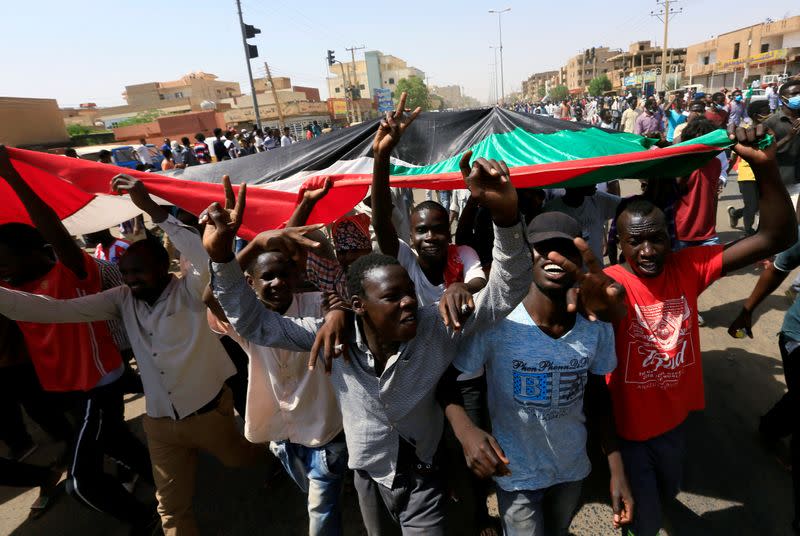 Civilians chant slogans as members of Sudanese pro-democracy protest on the anniversary of a major anti-military protest, as groups loyal to toppled leader Omar al-Bashir plan rival demonstrations in Khartoum