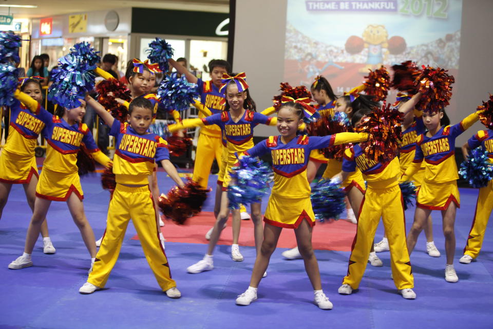 Winners from Si Ling Primary School perform a routine with red and blue pom poms.
