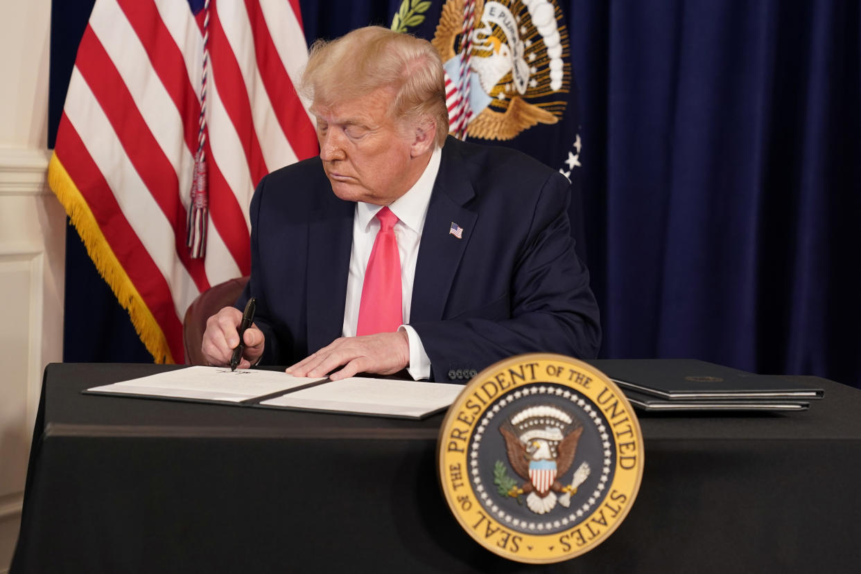 U.S. President Donald Trump signs executive orders for economic relief during a news conference amid the spread of the coronavirus disease (COVID-19), at his golf resort in Bedminster, New Jersey, U.S., August 8, 2020. REUTERS/Joshua Roberts