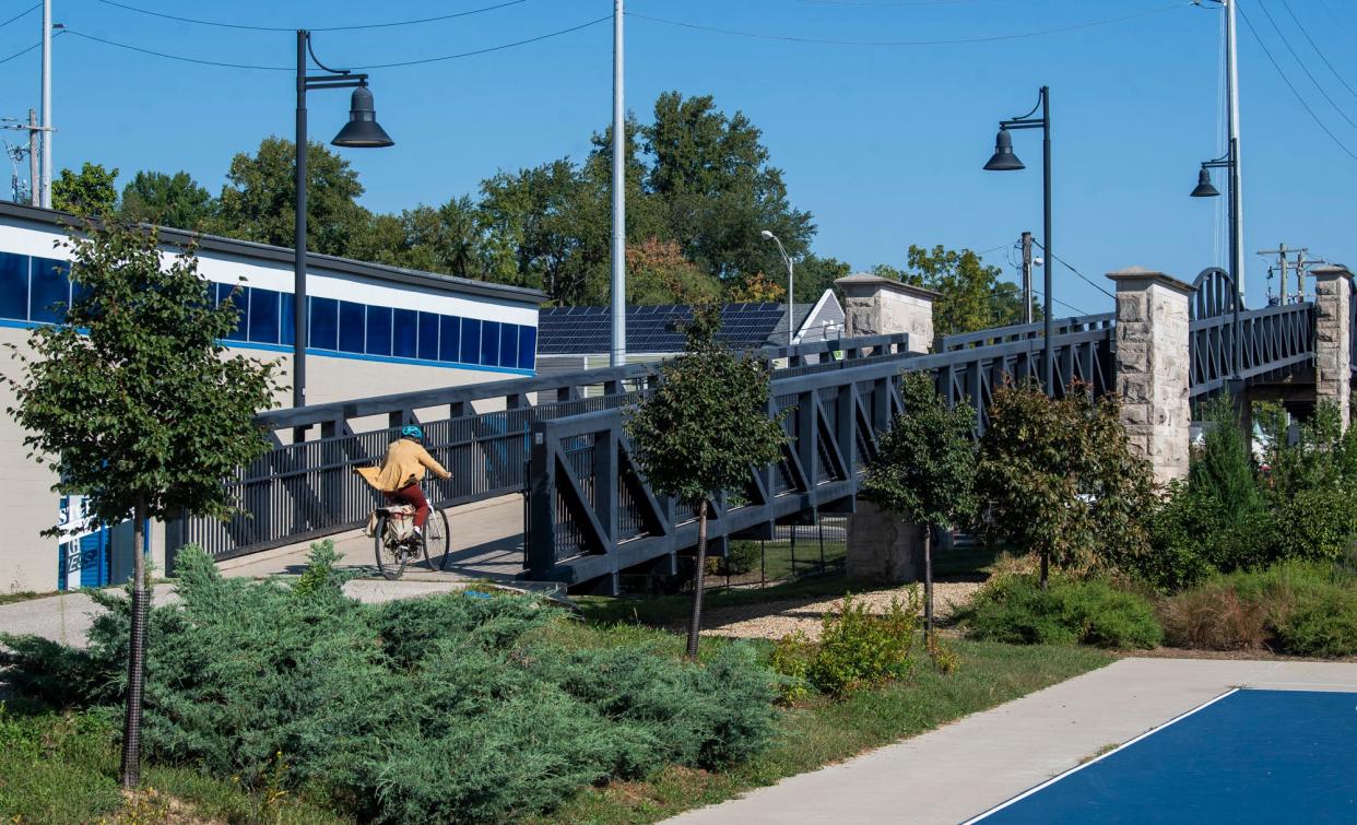 A person rides a bicycle over the Grimes Street pedestrian bridge near Switchyard Park in September.