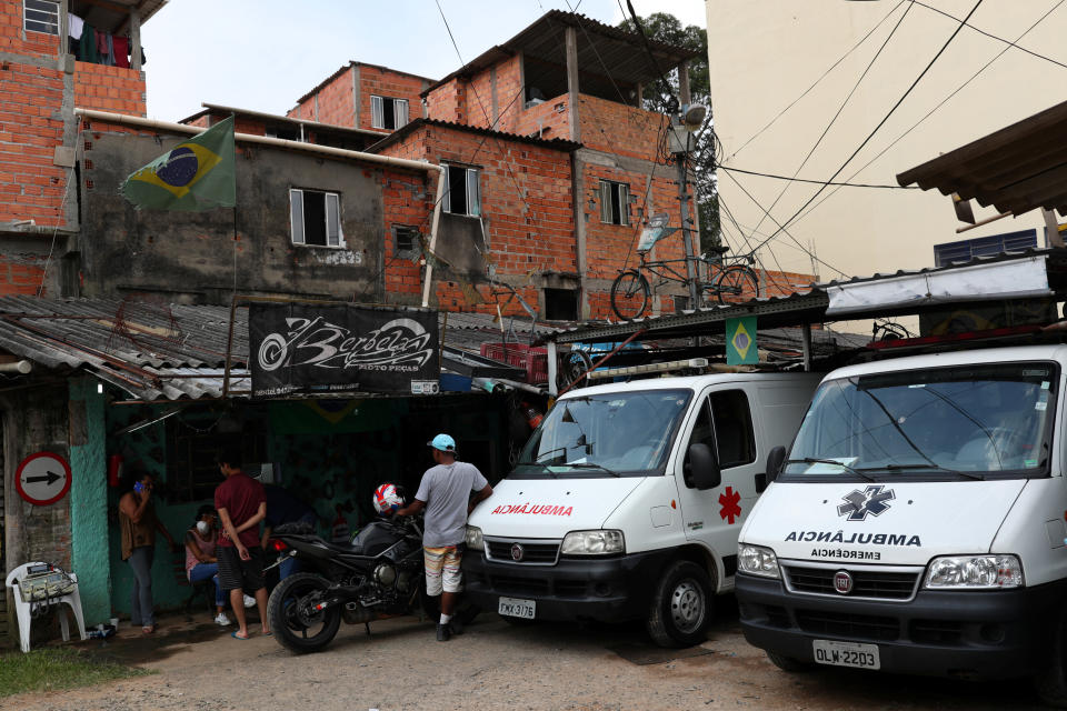People gather next to ambulances on March 29, 2020, after residents of S&atilde;o Paulo's biggest favela, Parais&oacute;polis, hired an around-the-clock private medical service to fight COVID-19. (Photo: Amanda Perobelli / Reuters)