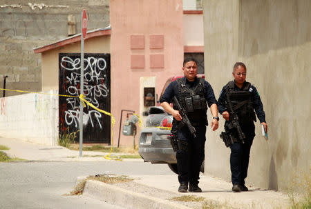 Police officers walk near a crime scene where the bodies of several people were found inside a house, days before the visit of Mexico's President-Elect Andres Manuel Lopez Obrador, in Ciudad Juarez, Mexico August 3, 2018. REUTERS/Jose Luis Gonzalez