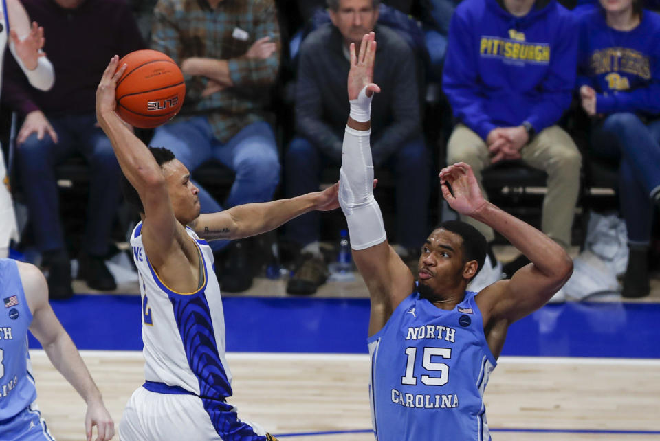 Pittsburgh's Trey McGowens, left, tries to go over North Carolina's Garrison Brooks (15), but lost the ball as he was fouled by Brooks during the second half of an NCAA college basketball game, Saturday, Jan. 18, 2020, in Pittsburgh. Pittsburgh won 66-52. (AP Photo/Keith Srakocic)