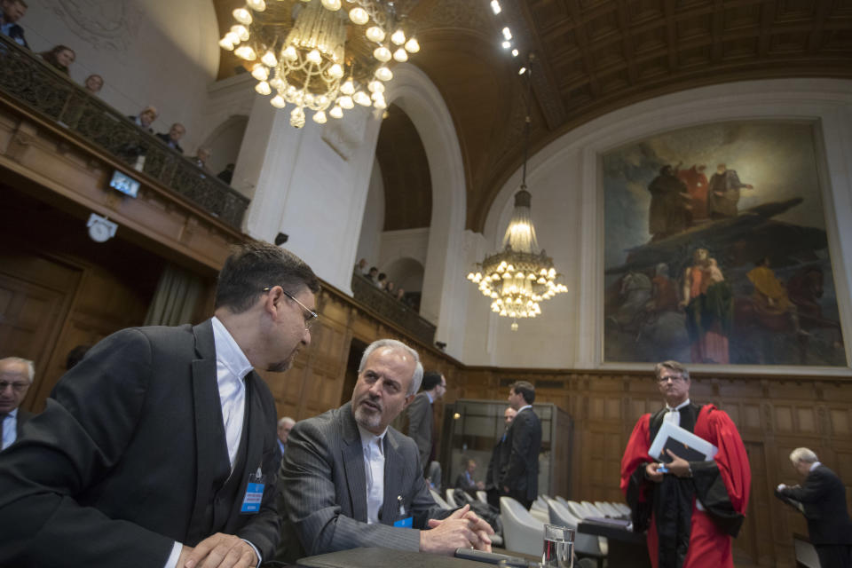 Mohammed Zahedin Labbaf, second left, agent for the Islamic Republic of Iran, waits for judges to enter the International Court of Justice, or World Court, in The Hague, Netherlands, Wednesday, Oct. 3, 2018, where judges ruled on an Iranian request to order Washington to suspend sanctions against Tehran. (AP Photo/Peter Dejong)