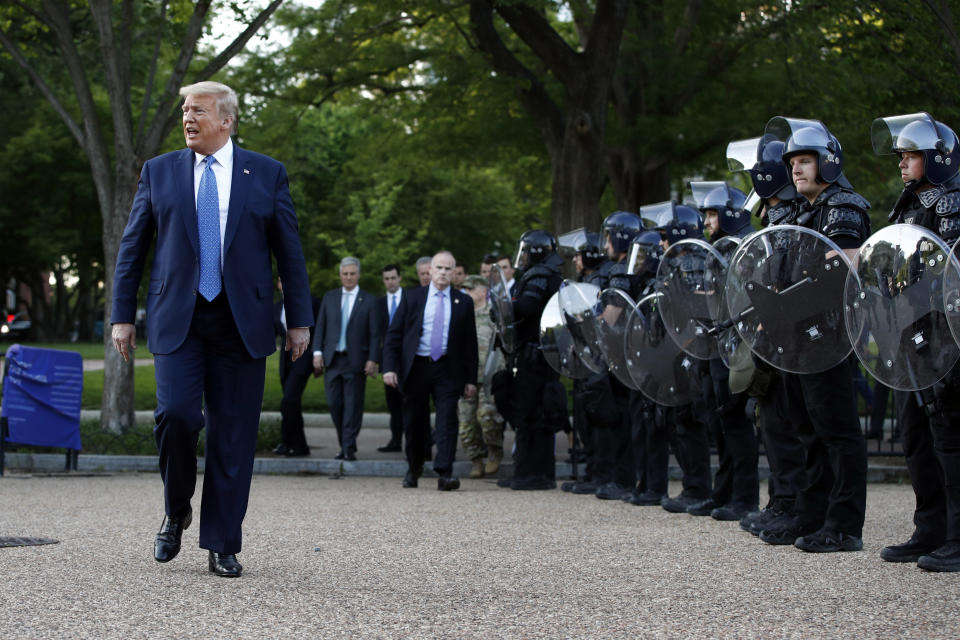 El presidente Donald Trump camina el lunes 1 de junio de 2020 junto a agentes policiales en el parque Lafayette frente a la Casa Blanca, en Washington. (AP Foto/Patrick Semansky)