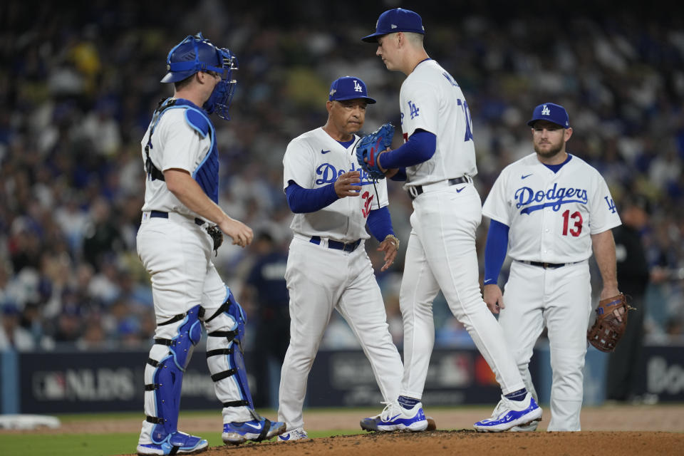 Los Angeles Dodgers starting pitcher Bobby Miller, second from right, is taken out of the game by manager Dave Roberts, second from left, in Game 2 of a baseball NL Division Series against the Arizona Diamondbacks, Monday, Oct. 9, 2023, in Los Angeles. (AP Photo/Ashley Landis)