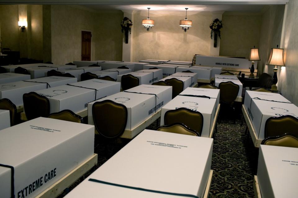 Bodies in boxes in the chapel of a funeral home.