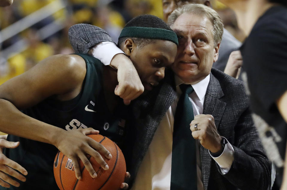 Michigan State head coach Tom Izzo holds guard Cassius Winston during the second half of an NCAA college basketball game against Michigan, Sunday, Feb. 24, 2019, in Ann Arbor, Mich. (AP Photo/Carlos Osorio)