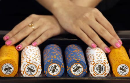 Test chips with security measures by Gaming Partners International (GPI), a provider of casino currency and equipment, are displayed on a gaming table during the Global Gaming Expo Asia in Macau in this May 22, 2013 file photo. REUTERS/Bobby Yip