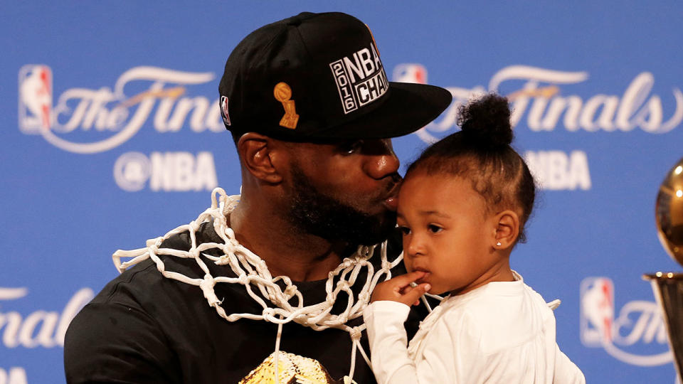 LeBron James gives his daughter Zhuri Nova James a kiss during a press conference after the Cavaliers beat the Golden State Warriors in Game 7 93-89 for the NBA Finals at Oracle Arena in Oakland, Calif., on Sunday, June 19, 2016. (Getty Images)