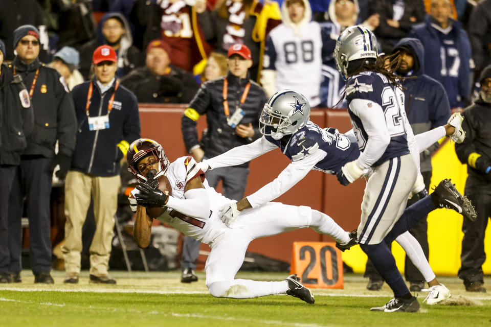 Washington Commanders wide receiver Terry McLaurin, left, hauls in a pass from Sam Howell (not shown) as Dallas Cowboys cornerbacks Trayvon Mullen (37) and Malik Hooker (28) pursue during the second half of an NFL football game Sunday, Jan. 8, 2023, in Landover, Md. (Shaban Athuman/Richmond Times-Dispatch via AP)