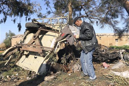 A man looks at the scene near a military base in Barsis, some 50 km (30 miles) outside Benghazi, after a suicide bomber detonated a truck packed with explosives at an army checkpoint December 22, 2013. Seven soldiers died in the first such attack since the revolution in Libya's deepening turmoil. REUTERS/Esam Omran Al-Fetori