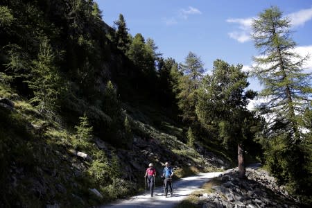 FILE PHOTO: Britain's Prime Minister Theresa May walks in a forest with her husband Philip at the start of a summer holiday in the Alps, in Switzerland