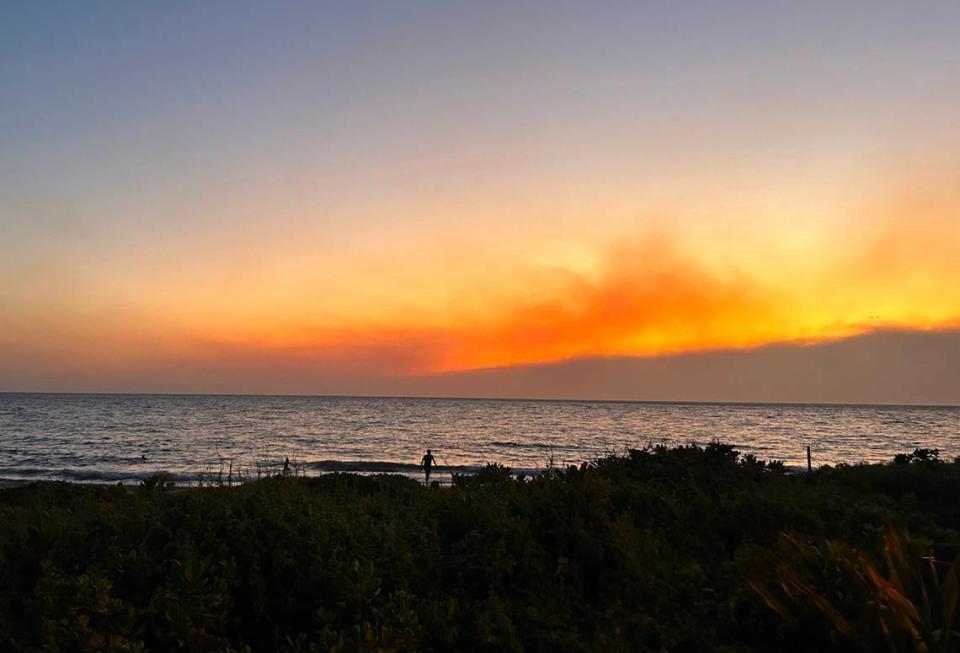 Smoke pools in the air from fires burning on Maui as the sun sets in Kihei on Tuesday.