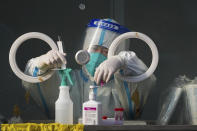 A medical worker wearing protective gear prepares swabs at a coronavirus test site in Xichen District in Beijing, Tuesday, Jan. 25, 2022. Hong Kong has already suspended many overseas flights and requires arrivals be quarantined, similar to mainland China's "zero-tolerance" approach to the virus that has placed millions under lockdowns and mandates mask wearing, rigorous case tracing and mass testing. (AP Photo/Andy Wong)