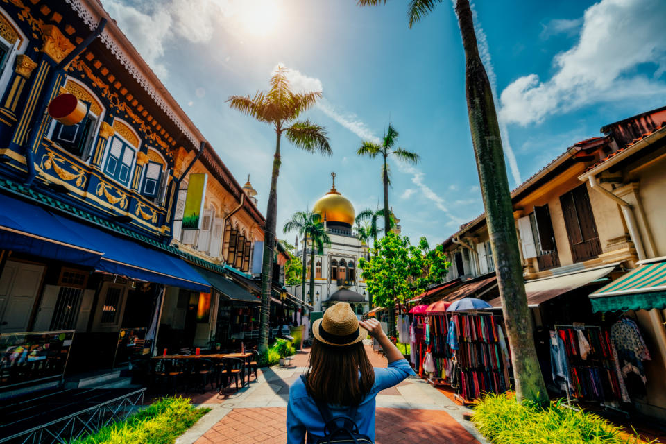 Young woman traveler traveling into The Masjid Sultan mosque located in Kampong Glam in Singapore city.