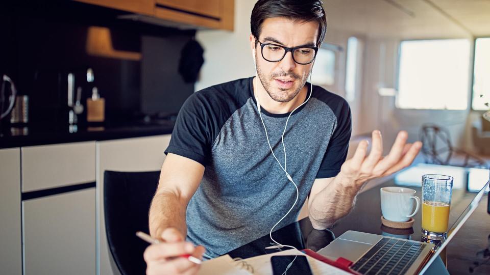 Man is working at home and video conferencing using his laptop.