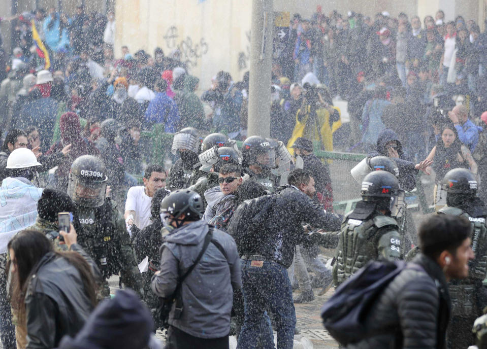 Police disperse anti-government protesters during a nationwide strike, at Bolivar square in downtown Bogota, Colombia, Thursday, Nov. 21, 2019. Colombia's main union groups and student activists called for a strike to protest the economic policies of Colombian President Ivan Duque government and a long list of grievances. (AP Photo/Fernando Vergara)