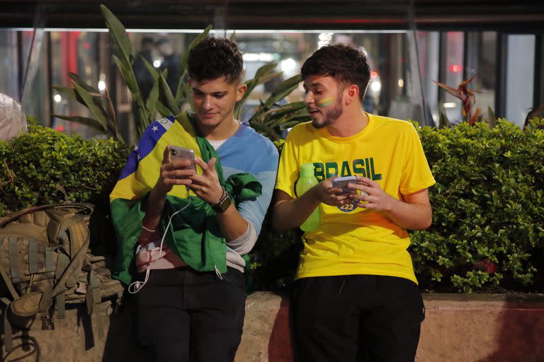 Los partidarios del presidente brasileño y candidato a la reelección Jair Bolsonaro reaccionan durante el conteo de votos de las elecciones legislativas y presidenciales, en Sao Paulo, Brasil, el 2 de octubre de 2022. - Los brasileños votaron el domingo en una elección presidencial polarizada en la que el favorito Luiz Ignacio Lula da Silva espera participar en la primera ronda, ya que el titular Jair Bolsonaro dice que aceptará el resultado si es "limpio". (Foto de CAIO GUATELLI / varias fuentes / AFP)
