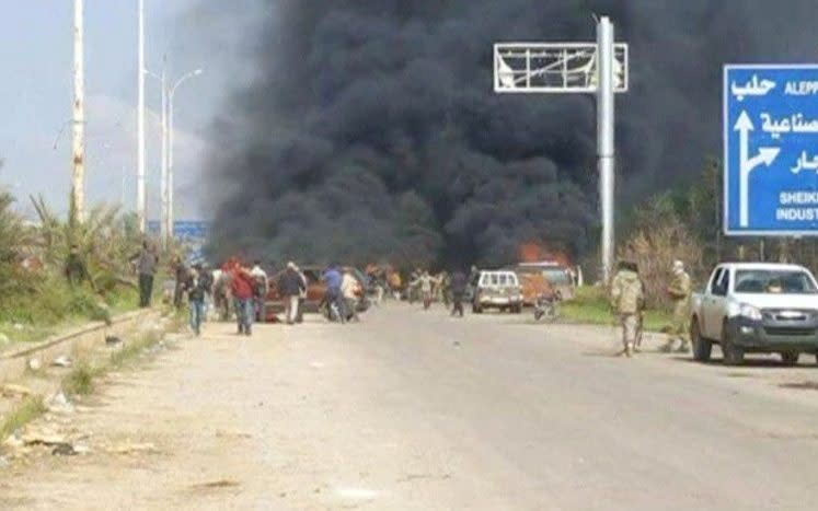 A cloud of black smoke rising from vehicles in the distance in what is said to be Aleppo's outskirts - Credit: Reuters