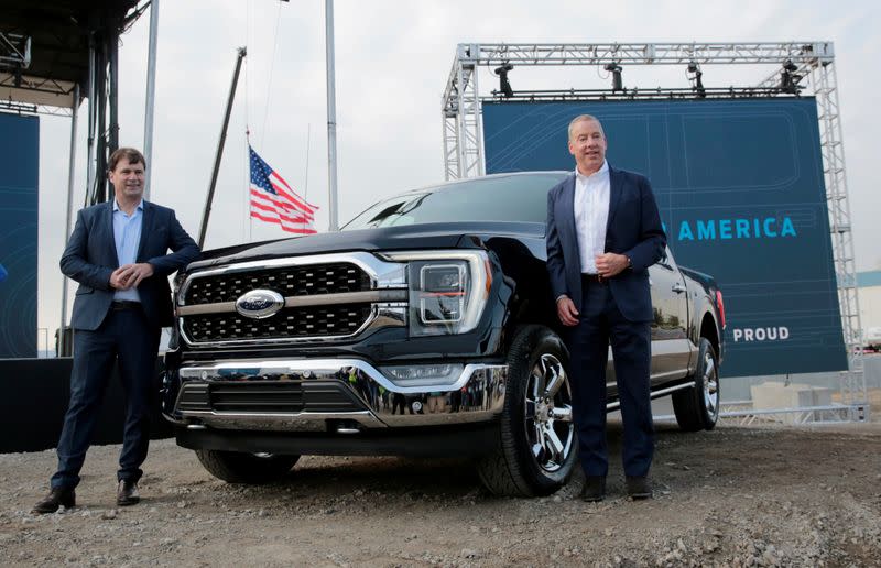 FILE PHOTO: Ford Motor Co. CEO Jim Farley and Executive Chairman Bill Ford Jr. pose next to a new 2021 Ford F-150 pickup truck in Dearborn, Michigan