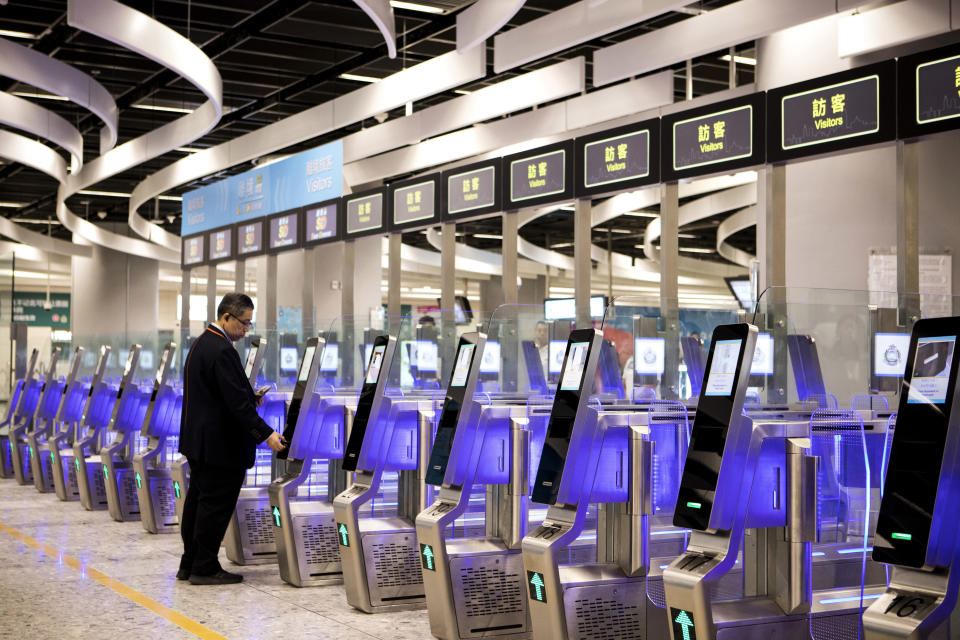 A man uses an automated immigration clearance machine for departing passengers in the Hong Kong Port Area at West Kowloon Station, which houses the terminal for the Guangzhou-Shenzhen-Hong Kong Express Rail Link (XRL) in Hong Kong, Saturday, Sept. 22, 2018. (Giulia Marchi/Pool Photo via AP)