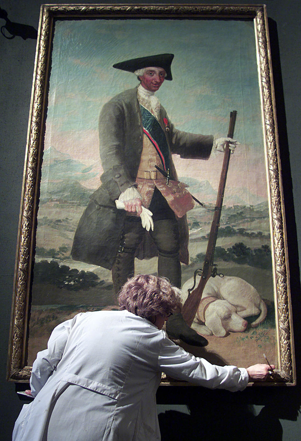 An Italian restorer cleans the oil painting frame called 