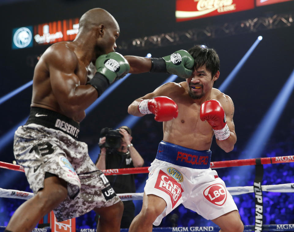 Timothy Bradley, left, lands a left to the head of Manny Pacquiao, of the Philippines, in their WBO welterweight title boxing fight Saturday, April 12, 2014, in Las Vegas. (AP Photo/Eric Jamison)