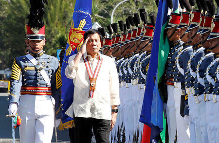 Philippine President Rodrigo Duterte salutes during arrival honours at the Philippine Military Academy in Baguio city, in northern Philippines March 12, 2017. REUTERS/Harley Palangchao