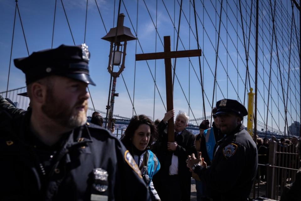 Jonathan Fields carries a cross over the Brooklyn Bridge on Friday. Stefan Jeremiah for NY Post