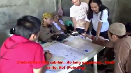 FILE PHOTO : Men identified by Philippines Intelligence officers as Isnilon Hapilon (2nd L, yellow headscarf) and Abdullah Maute (2nd R, standing, long hair) are seen in this still image taken from video released by the Armed Forces of the Philippines on June 7, 2017. Armed Forces of the Philippines/Handout via REUTERS TV/File Photo