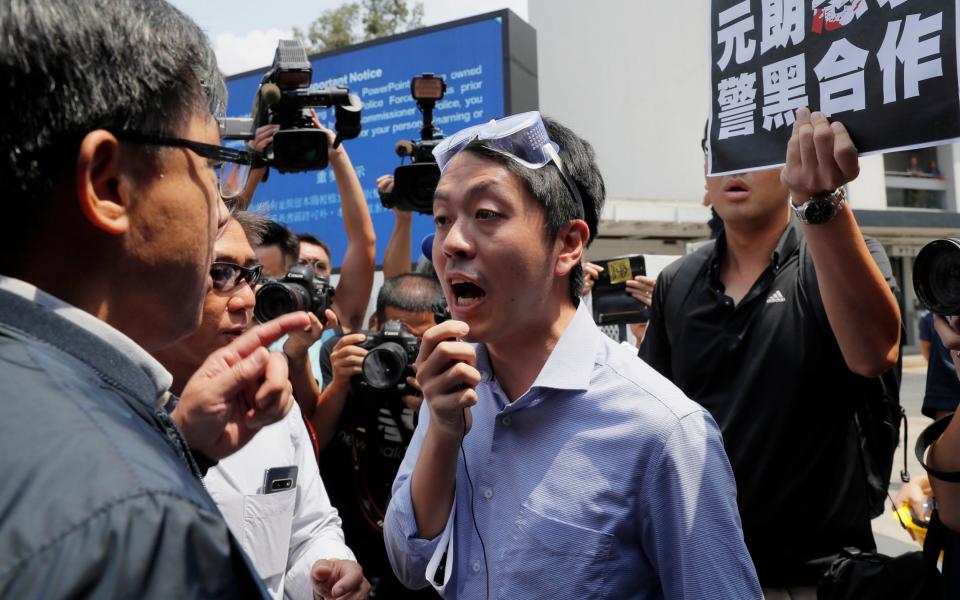 Ted Hui, centre, argues with pro-Beijing lawmaker Junius Ho, left, during a demonstration in 2019 - AP Photo/Kin Cheung, File