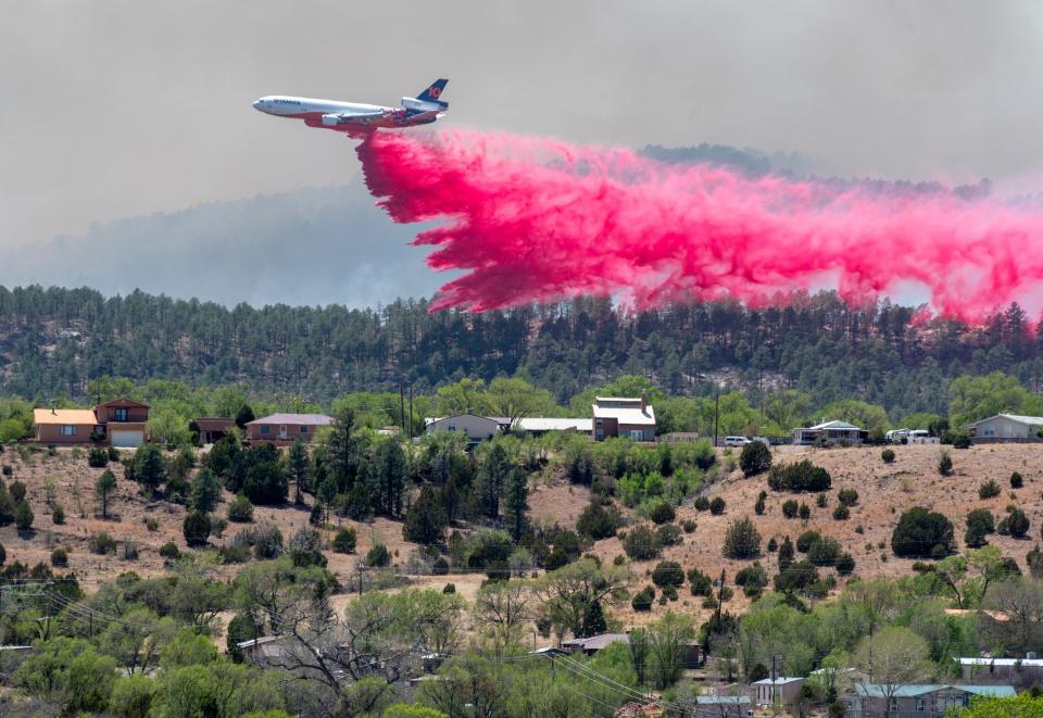 A slurry bomber dumps the fire retardant between the Calf Canyon/Hermit Peak Fire and homes on the west side of Las Vegas, N.M., on May 3. Several types of aircraft joined the fight to keep the fire away from the Northern New Mexico town.