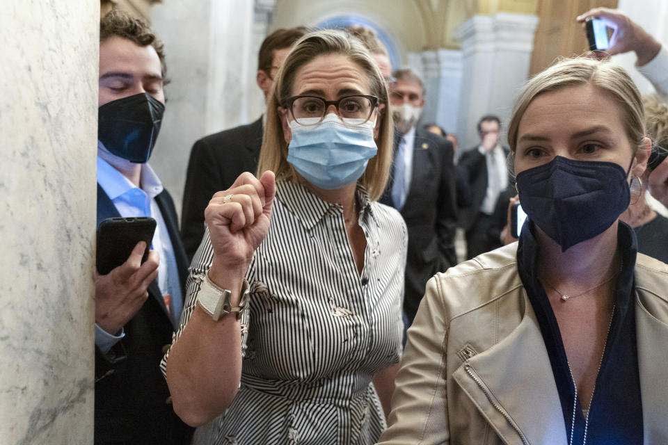 FILE - Sen. Kyrsten Sinema, D-Ariz., center, followed by Sen. Joe Manchin, D-W.Va., leaves their meeting, Oct. 27, 2021, on Capitol Hill in Washington. Sinema received a $1 million surge of campaign cash over the past year from private equity professionals, hedge funds and venture capitalists whose interests she has staunchly defended in Congress. That's according to an Associated Press review of campaign finance disclosures. (AP Photo/Jacquelyn Martin, File)