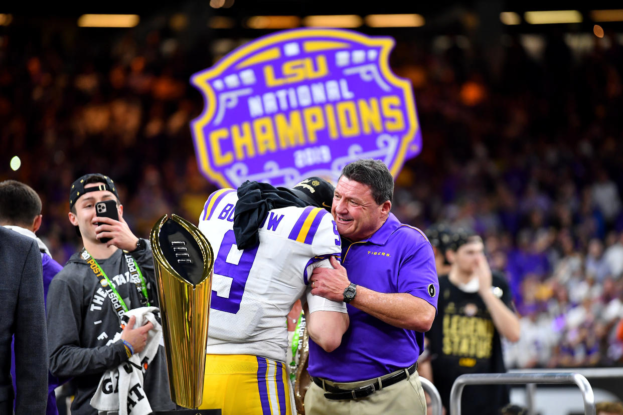 NEW ORLEANS, LOUISIANA - JANUARY 13: Head coach Ed Orgeron of the LSU Tigers, right, and Joe Burrow #9 hug on the championship stage after the College Football Playoff National Championship game against the Clemson Tigers at the Mercedes Benz Superdome on January 13, 2020 in New Orleans, Louisiana. The LSU Tigers topped the Clemson Tigers, 42-25. (Photo by Alika Jenner/Getty Images)