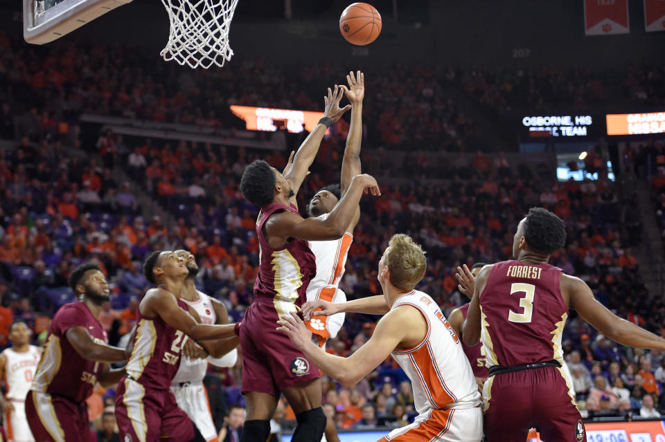 Clemson's John Newman lll, center right, shoots while defended by Florida State's Malik Osborne, center left, during the first half of an NCAA college basketball game Saturday, Feb. 29, 2020, in Clemson, S.C. (AP Photo/Richard Shiro)