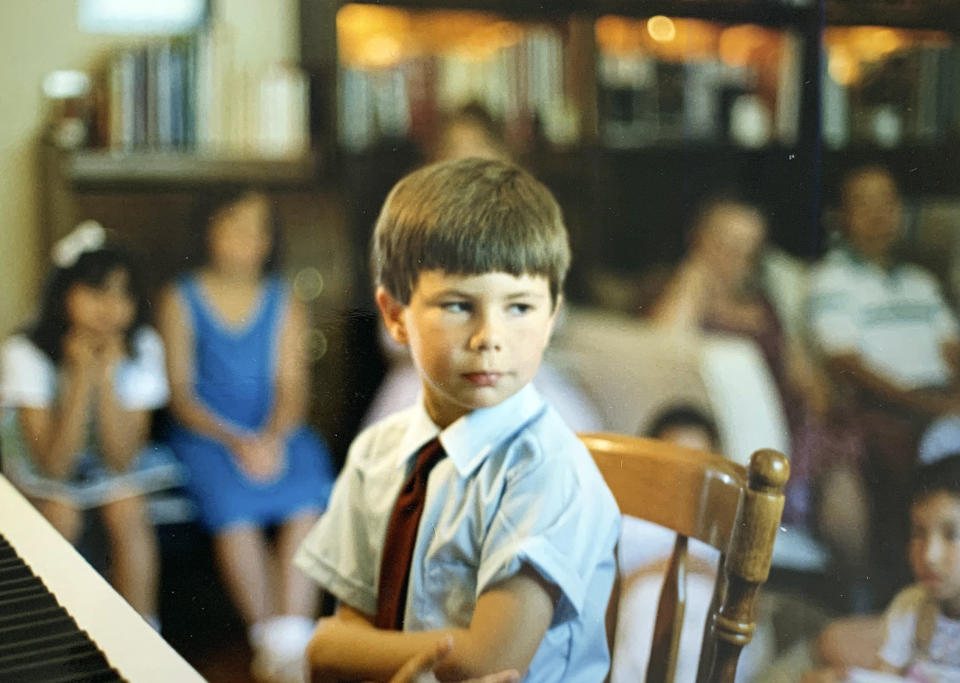 In this image provided by the Pete Buttigieg presidential campaign, Pete Buttigieg sits at a piano in a a Montessori graduation event for parents in South Bend, Ind., around 1987. (Pete Buttigieg Presidential Campaign via AP)